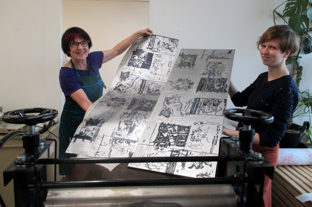 TARJA HEILIMO ESITTELEE UNIIKKIA PUUPIIRROSVEDOSTA, KUKAN KÄDESSÄ ON LAATTA